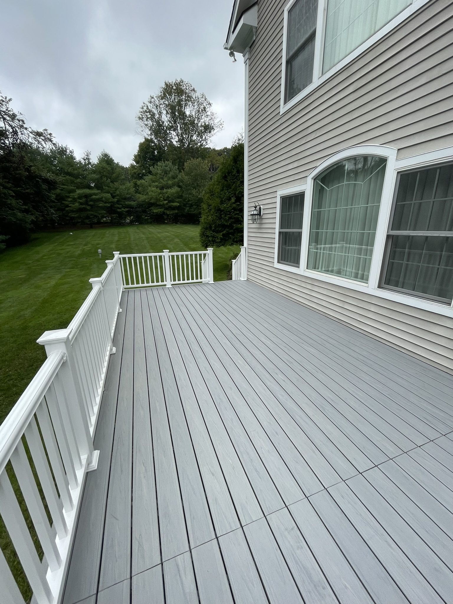 After: completed composite Trex deck with white vinyl railing — Westchester County NY