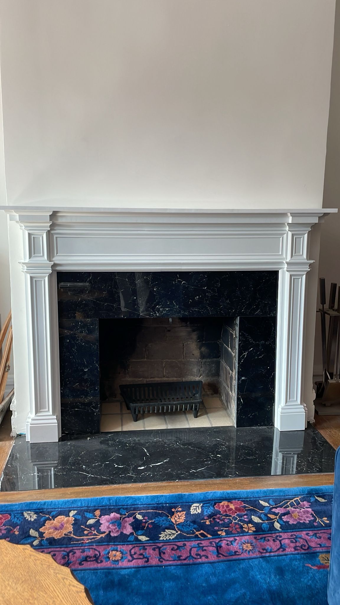 After: custom white fireplace mantel installed over Nero marble — Westchester NY